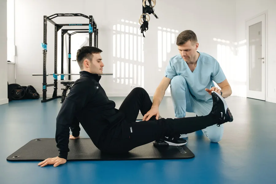 Sala ampla de atendimento com colchonete e equipamentos de fisioterapia
